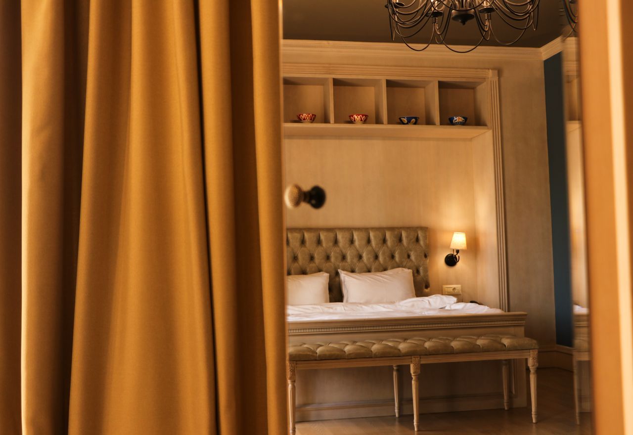 services-img Elegant hotel room in Baku featuring stylish decor, plush bedding, and warm lighting, creating a cozy atmosphere.
