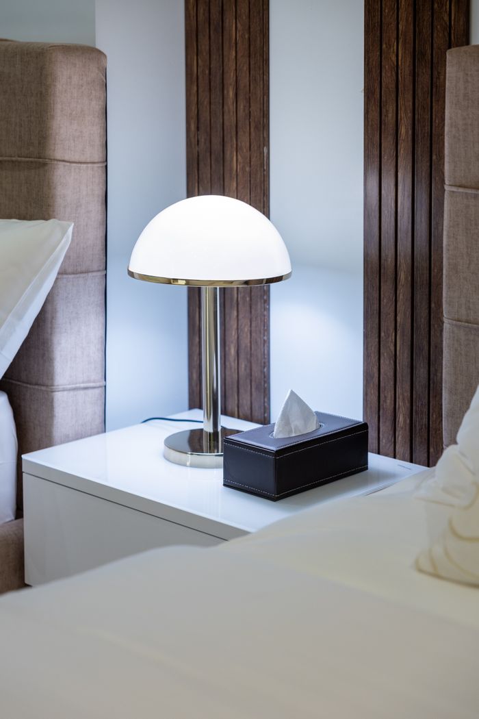 services-03 Modern hotel room in Dubai featuring a stylish nightstand lamp and luxurious decor.