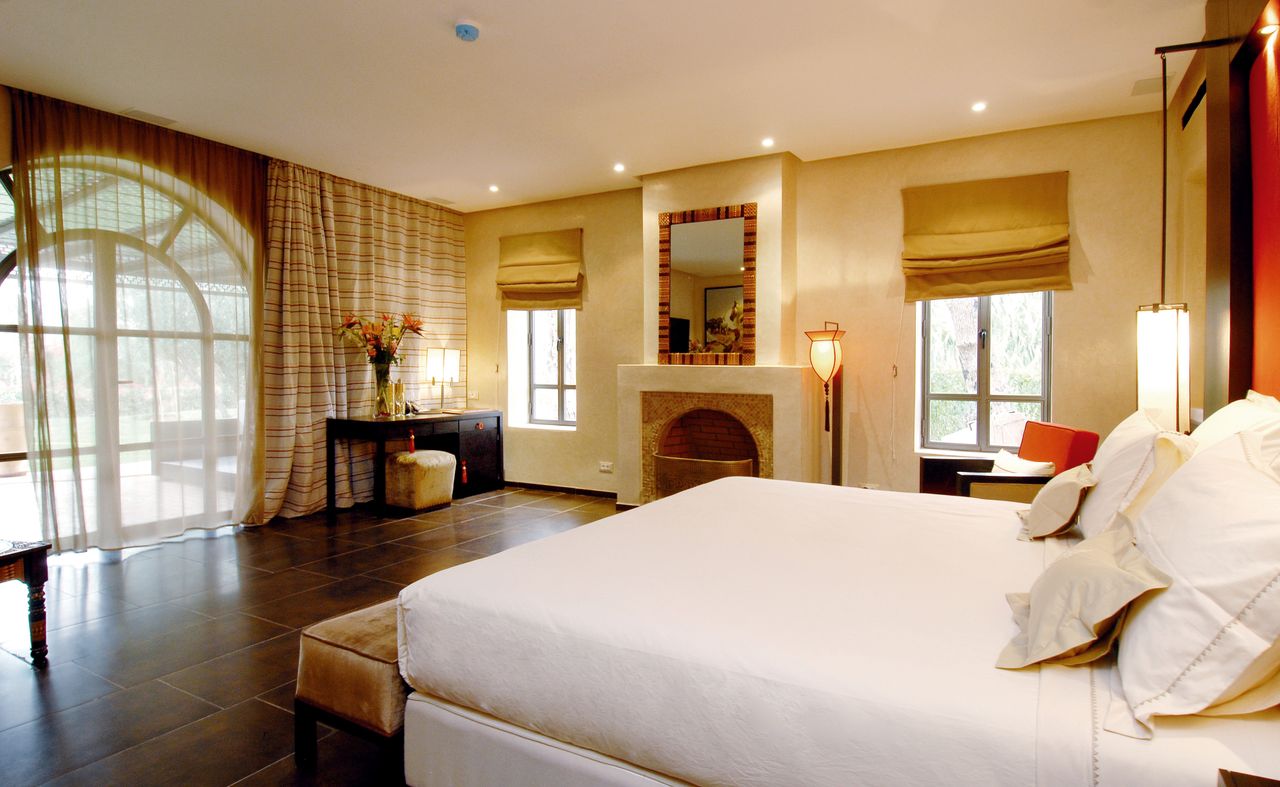 hero-img-01 Spacious modern bedroom with elegant decor and large windows offering natural light.
